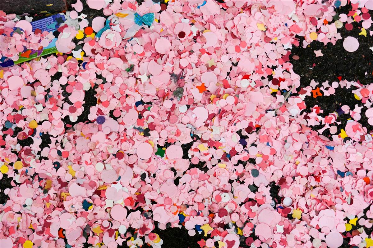Close-up of colourful confetti scattered across the ground after a celebration