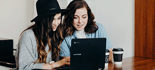two women playing online bingo on laptop